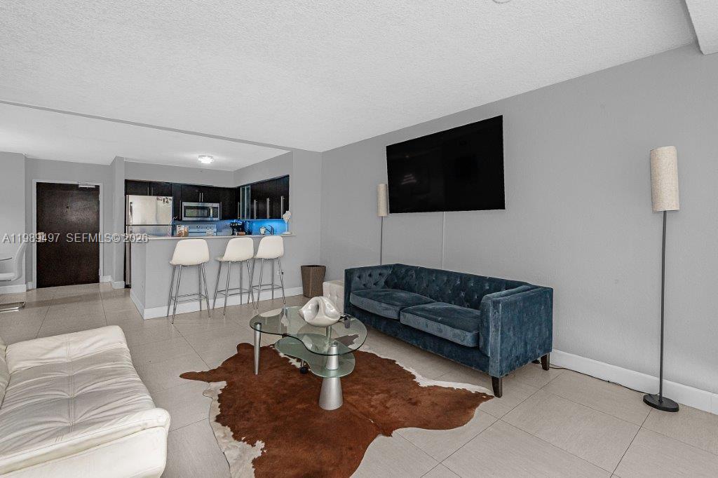 1500 Bay Road, Unit 128S Miami Beach, FL 33139 - Photo 16 of 27 a living room with furniture and a flat screen tv
