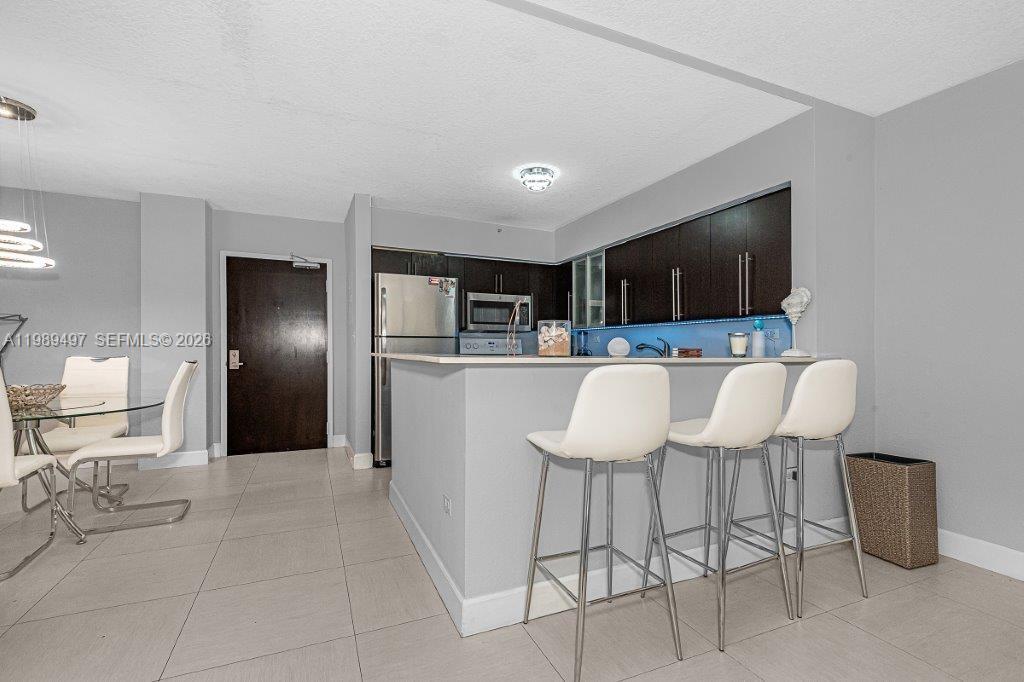1500 Bay Road, Unit 128S Miami Beach, FL 33139 - Photo 17 of 27 a kitchen with a refrigerator and chairs