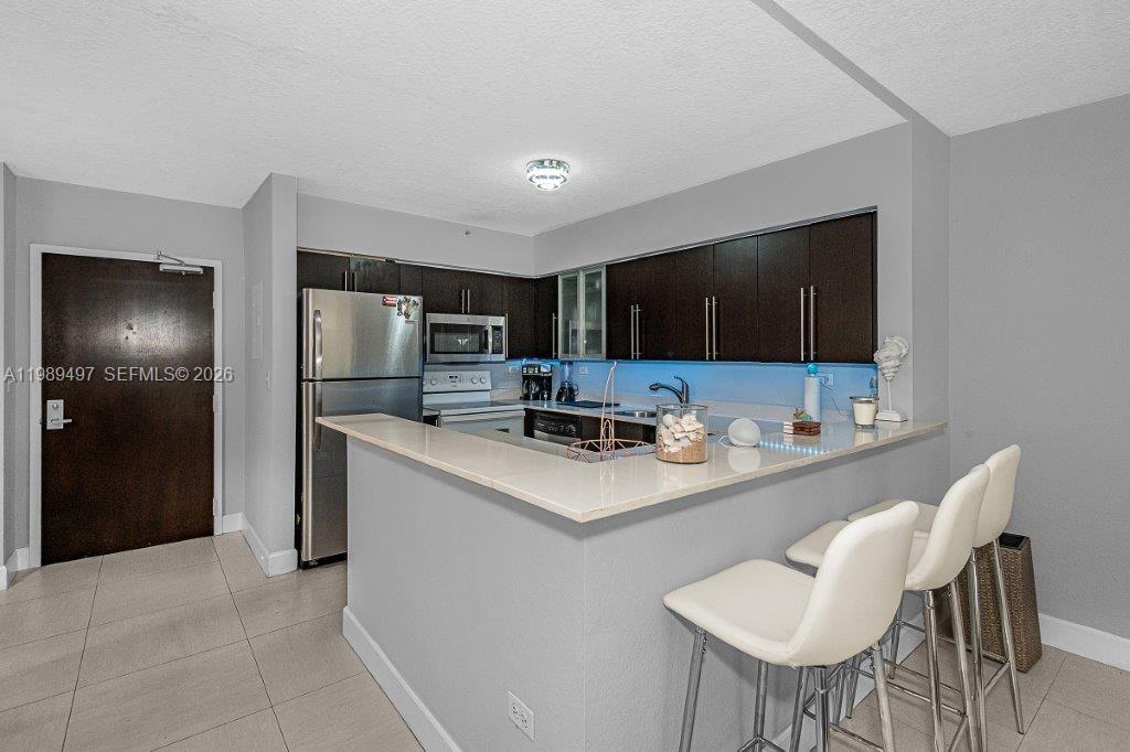 1500 Bay Road, Unit 128S Miami Beach, FL 33139 - Photo 20 of 27 a kitchen with stainless steel appliances a microwave sink refrigerator and cabinets