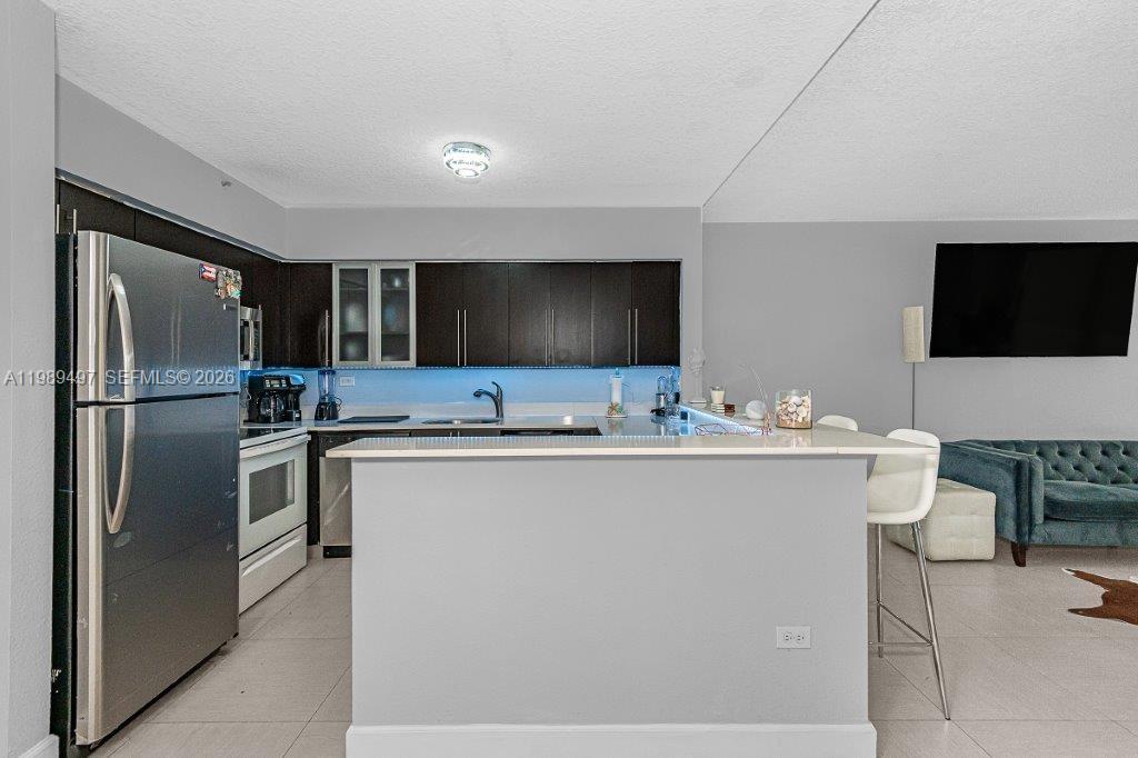 1500 Bay Road, Unit 128S Miami Beach, FL 33139 - Photo 21 of 27 a kitchen with a sink stainless steel appliances and cabinets