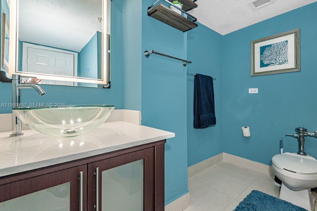 1500 Bay Road, Unit 128S Miami Beach, FL 33139 - Photo 6 of 27 a bathroom with a sink a toilet and mirror