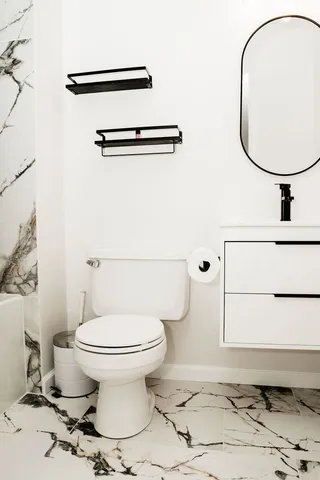 a white toilet sitting next to a bath tub