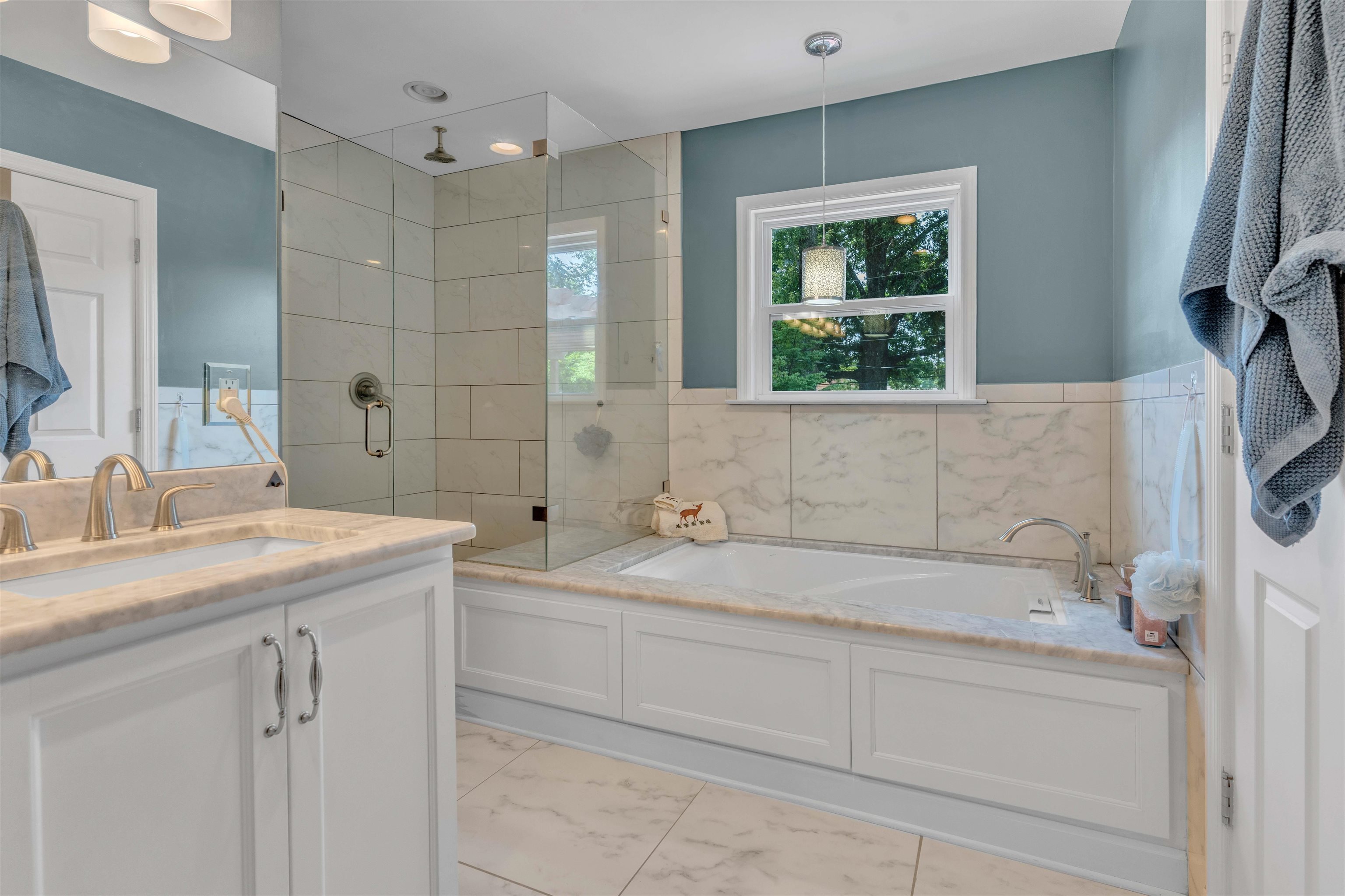 5187 South Angela Road Memphis, TN 38117 - Photo 19 of 39 Bathroom featuring a built-in soaking tub, glass-enclosed shower with subway tile surround, double vanity with stone countertop, and tile flooring