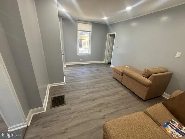 a view of a kitchen with refrigerator and wooden floor