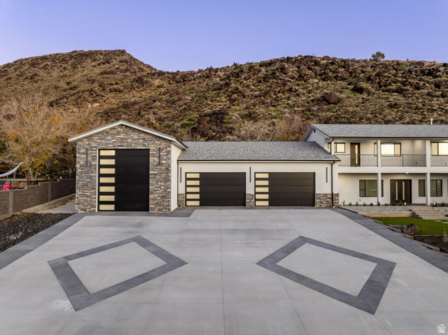 476 Spring Drive Toquerville, UT 84774 - Photo 7 of 95 View of front facade with stone siding, concrete driveway, stucco siding, a garage, and a mountain view