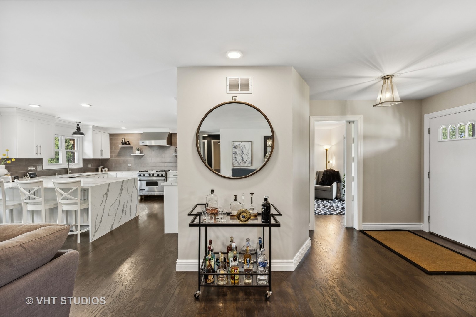 8460 Dolfor Cove Burr Ridge, IL 60527 - Photo 11 of 32 a living room with furniture a kitchen island a sink and a wooden floor