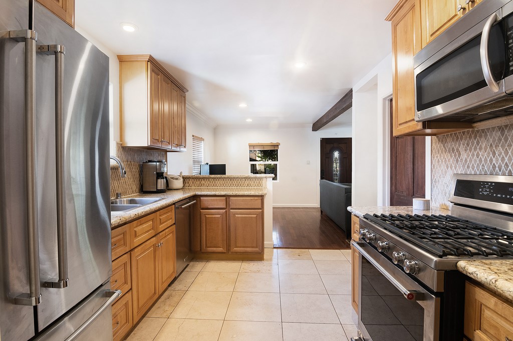 1935 Summit Avenue Pasadena, CA 91103 - Photo 9 of 27 a kitchen with stainless steel appliances granite countertop a stove top oven a sink dishwasher a refrigerator and cabinets with wooden floor