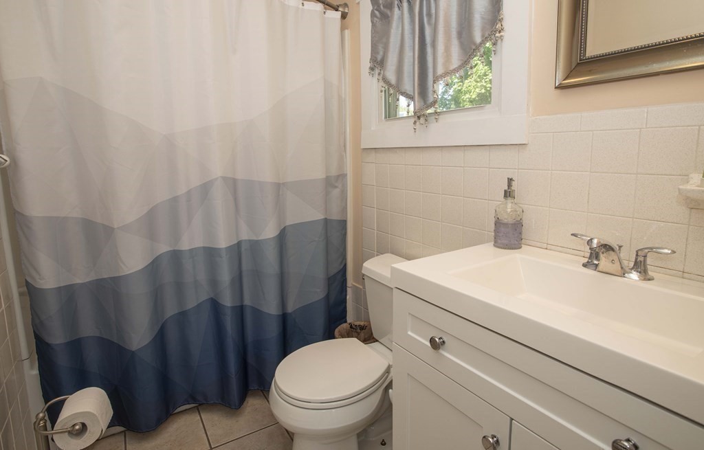 28 Augustine Street Brockton, MA 02301 - Photo 11 of 34 a bathroom with a sink a toilet and a shower curtain