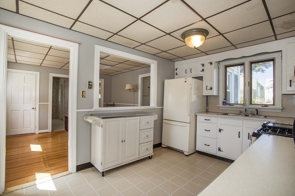 28 Augustine Street Brockton, MA 02301 - Photo 5 of 34 a large white kitchen with a stove a sink dishwasher and a refrigerator with wooden floor
