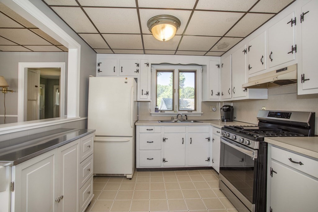 28 Augustine Street Brockton, MA 02301 - Photo 6 of 34 a kitchen with stainless steel appliances white cabinets a stove a sink and a refrigerator