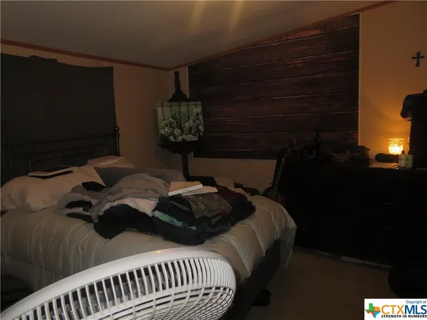 a bed sitting in a bedroom next to a lamp