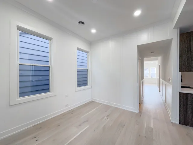 an empty room with wooden floor and a window