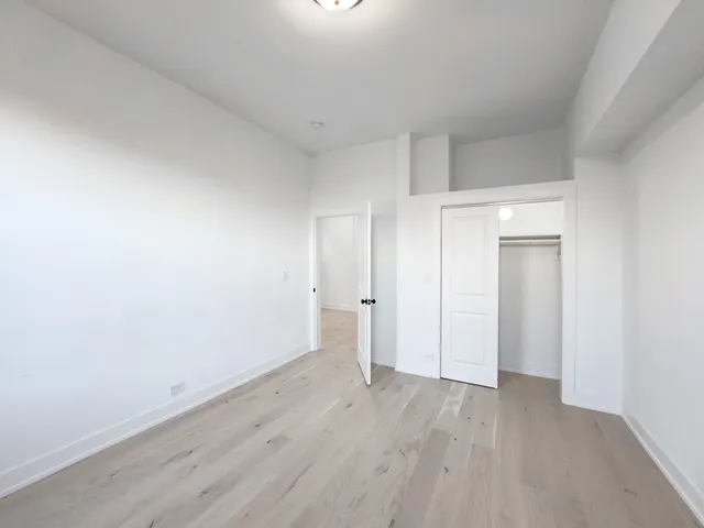a view of a room with wooden floor and white doors