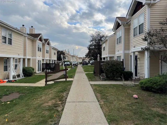 a view of a white house with a yard and plants
