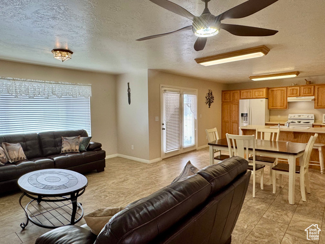445 Topaz Boulevard, Unit 10 Delta, UT 84624 - Photo 7 of 28 Living area featuring a textured ceiling, ceiling fan, baseboards, and light tile patterned flooring