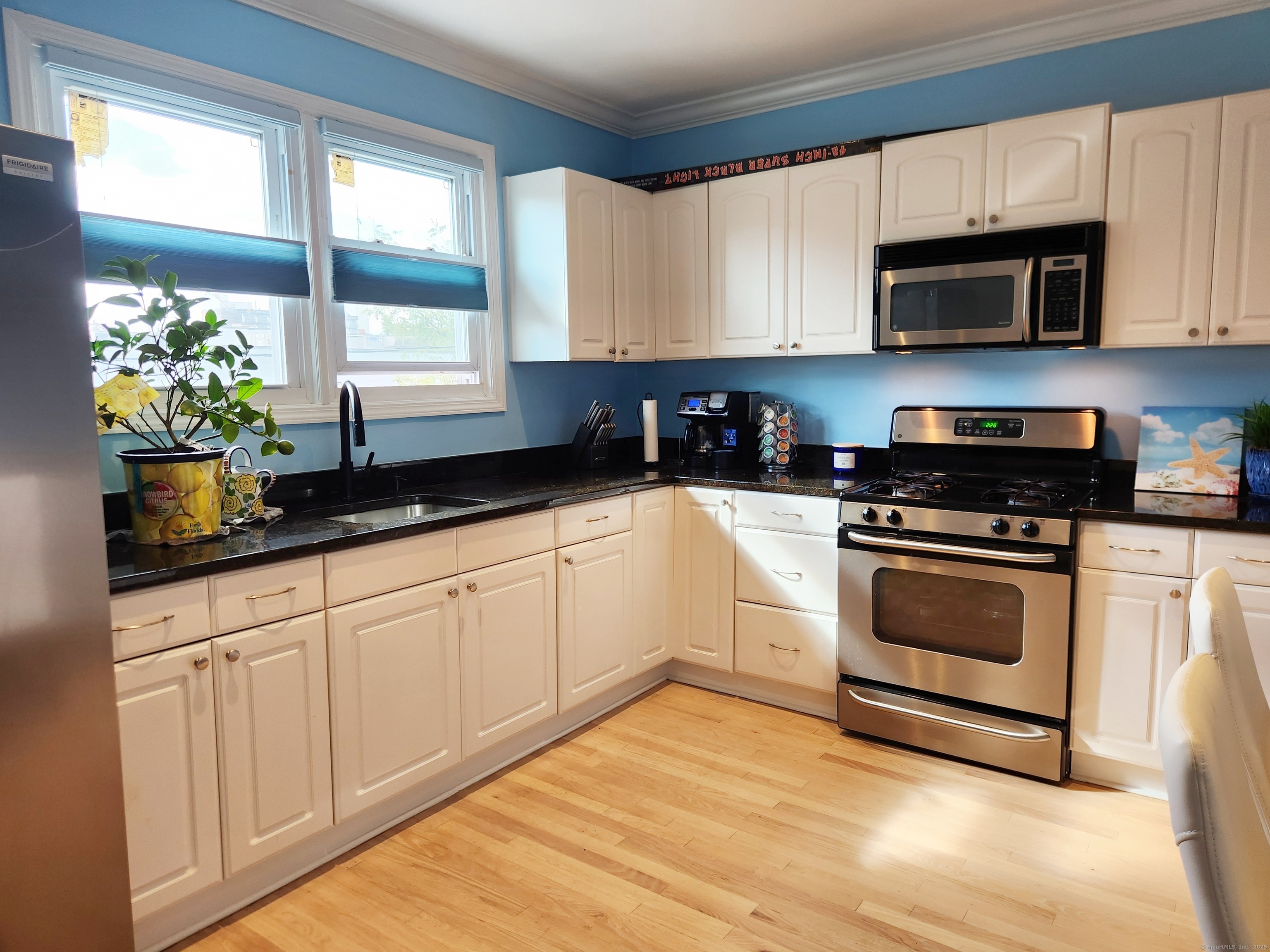 a kitchen with granite countertop white cabinets and white appliances