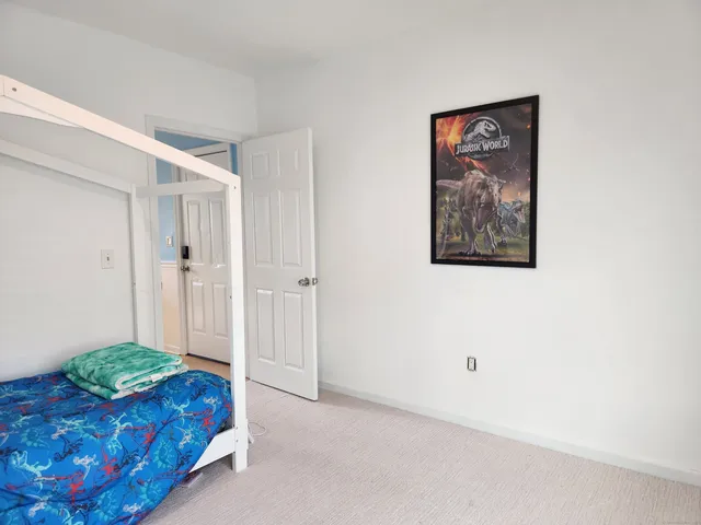 a spacious bedroom with a bed and a painting on the wall