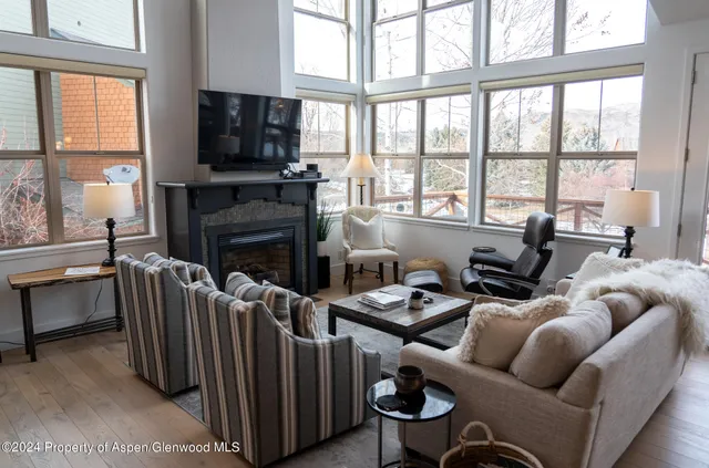 a living room with furniture a flat screen tv and a fireplace