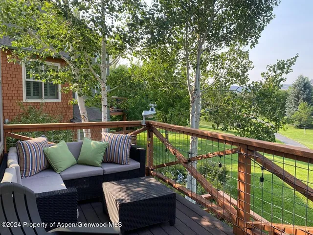 a balcony with wooden floor and outdoor seating