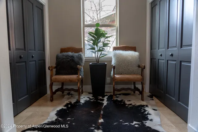 a dining room with furniture and a potted plant