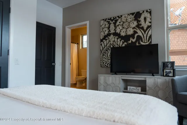 a bedroom with a bed and a flat screen tv