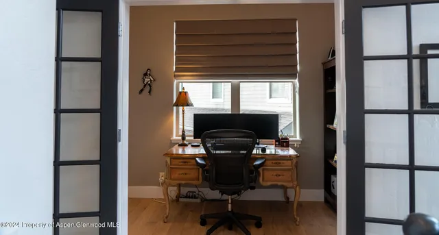 a view of a workspace with furniture and a window