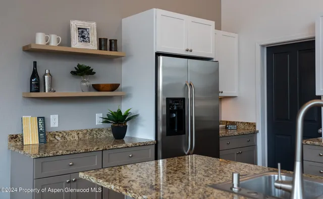 a kitchen with stainless steel appliances granite countertop a refrigerator and stove