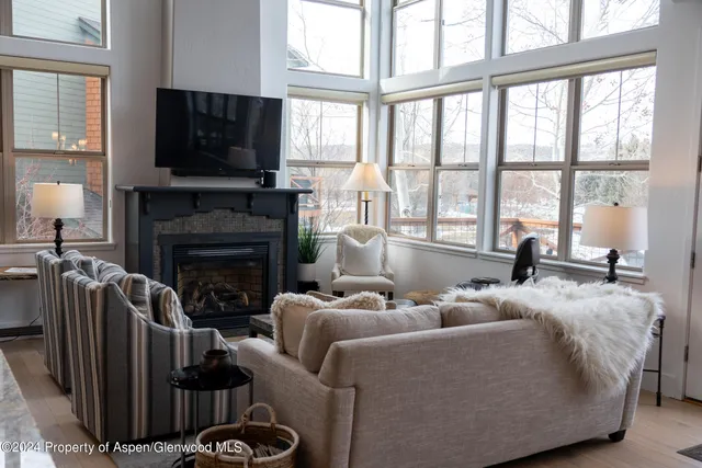 a living room with furniture a flat screen tv and a fireplace