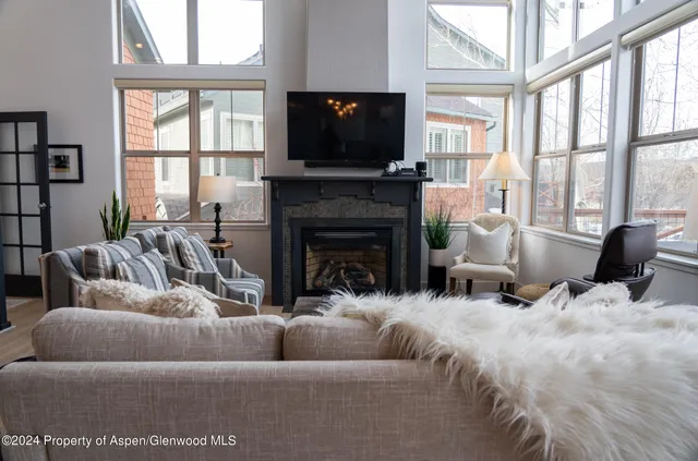 a living room with furniture a flat screen tv and a fireplace