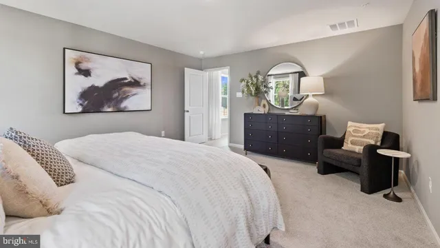 a bedroom with a bed and dresser with mirror
