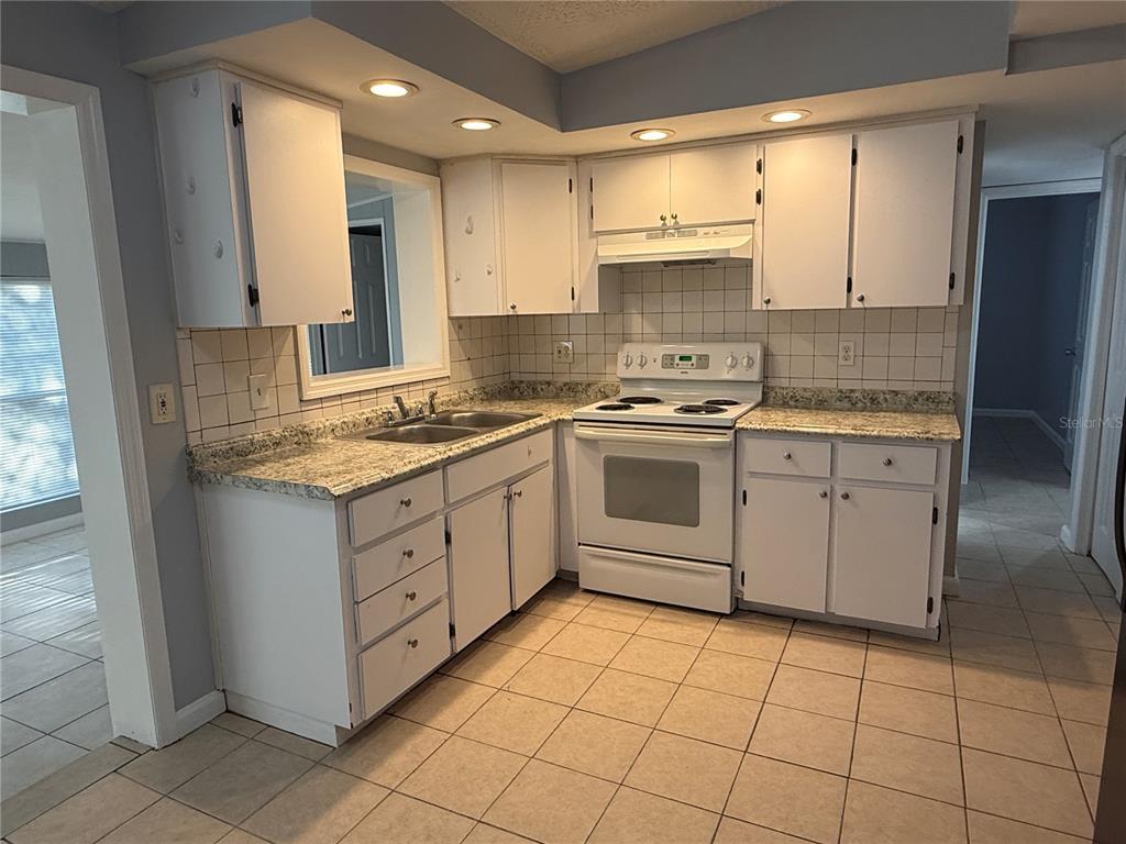 4117 Highland Loop New Port Richey, FL 34652 - Photo 6 of 12 a kitchen with a stove sink and cabinets