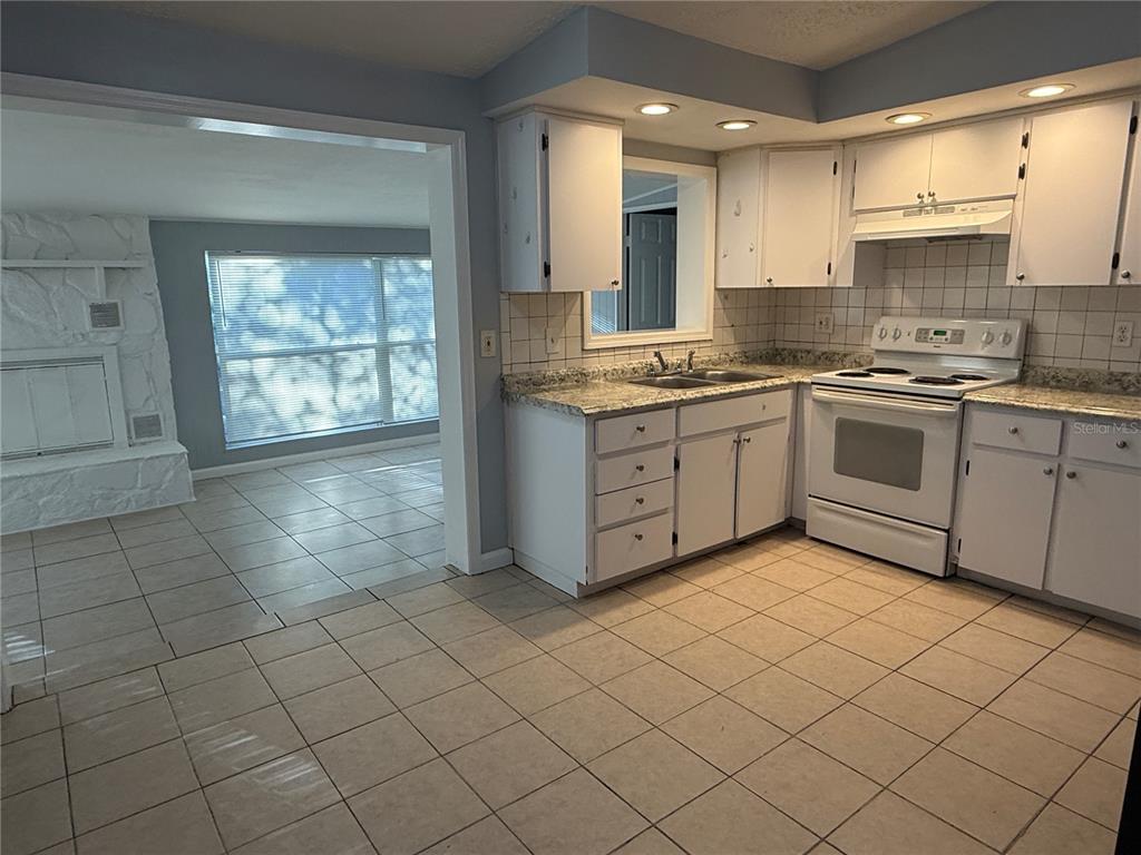 4117 Highland Loop New Port Richey, FL 34652 - Photo 7 of 12 a kitchen with stainless steel appliances granite countertop a sink and cabinets