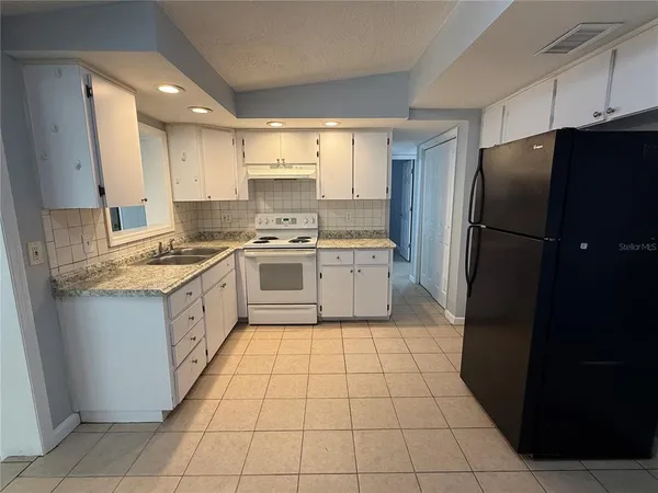 a kitchen with a stove a refrigerator and a sink