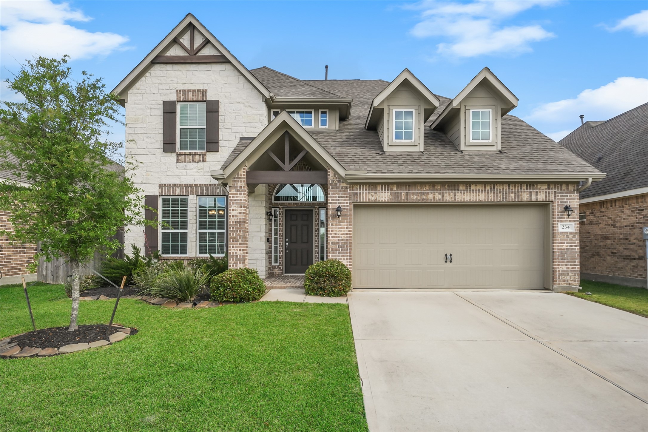 a front view of a house with a yard and garage