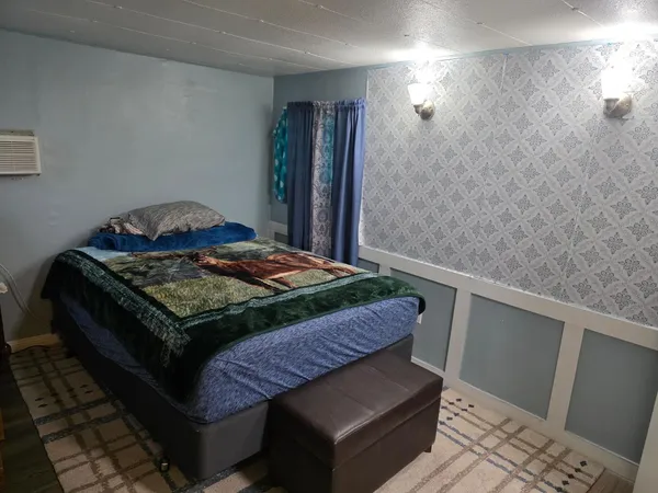 a bedroom with a bed and wooden floor