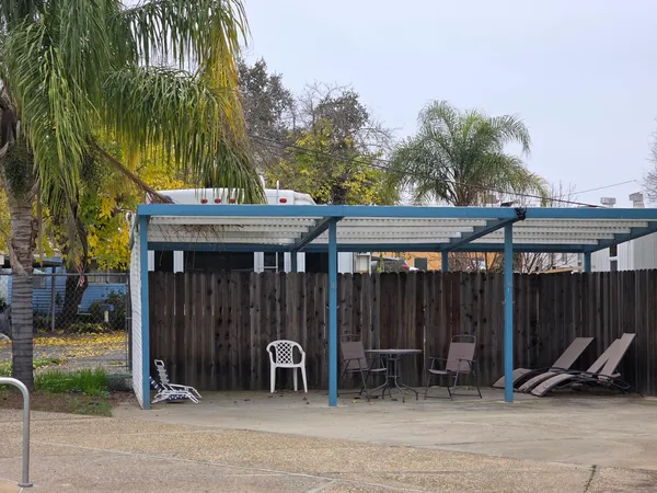 a view of a patio with table and chairs under an umbrella