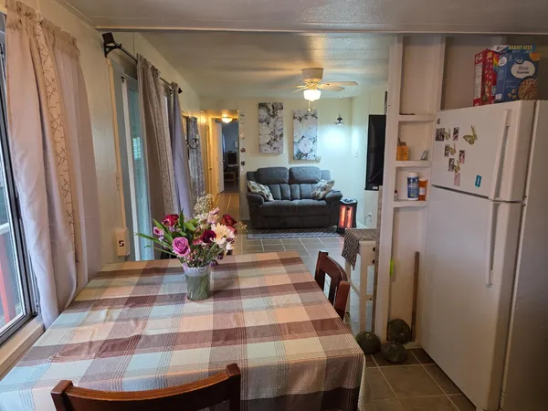 a view of a hallway with dining table and chairs