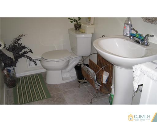 19 Huntington Road Edison, NJ 08820 - Photo 10 of 16 a bathroom with a sink toilet and mirror