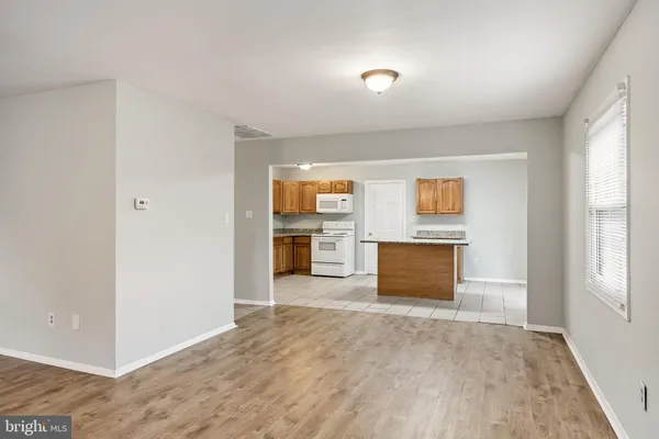 an empty room with kitchen and windows