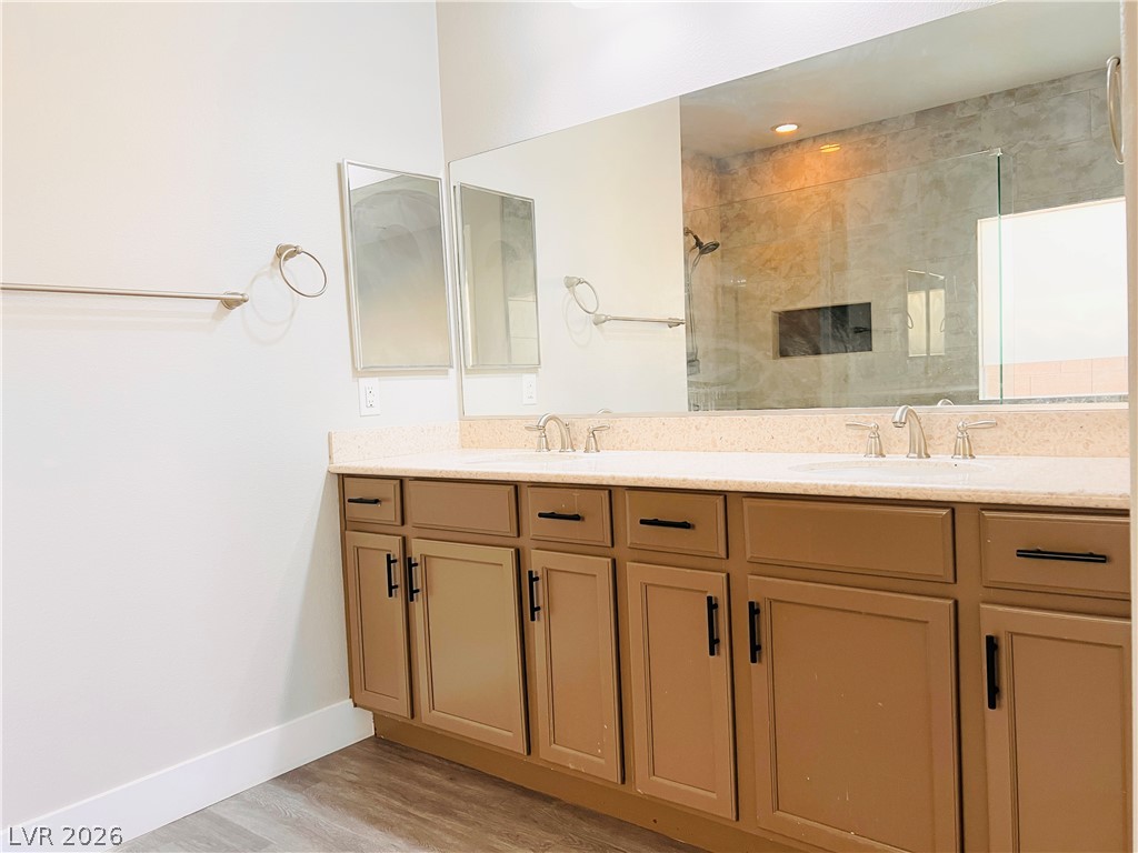 161 Dunblane Street Henderson, NV 89012 - Photo 19 of 56 A well-appointed bathroom vanity with dual sinks, offering ample storage and a clear view of the shower beyond.