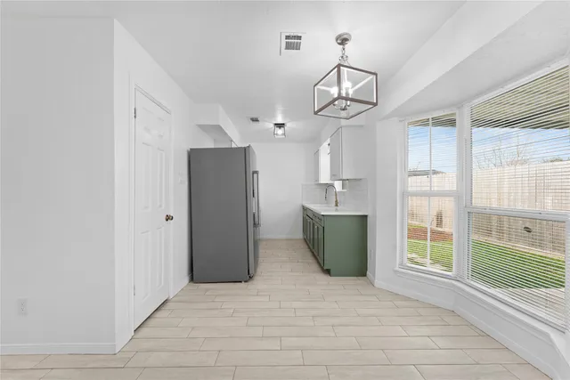 an empty room with a window and a fan