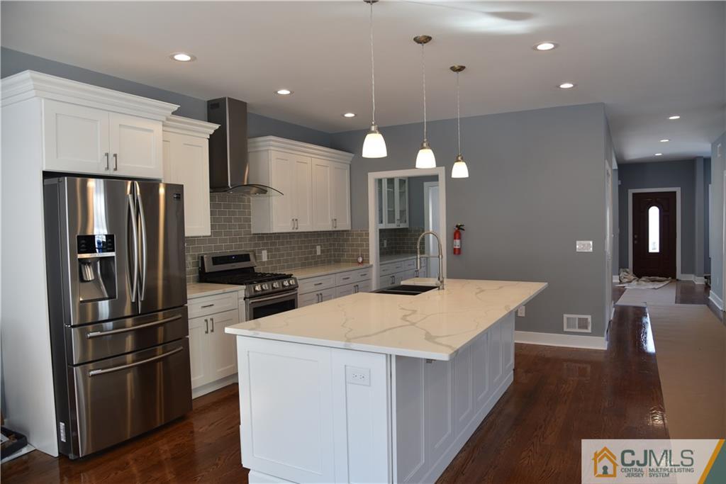 171 East Cliff Road Colonia, NJ 07067 - Photo 4 of 25 a kitchen with a refrigerator a sink and a stove
