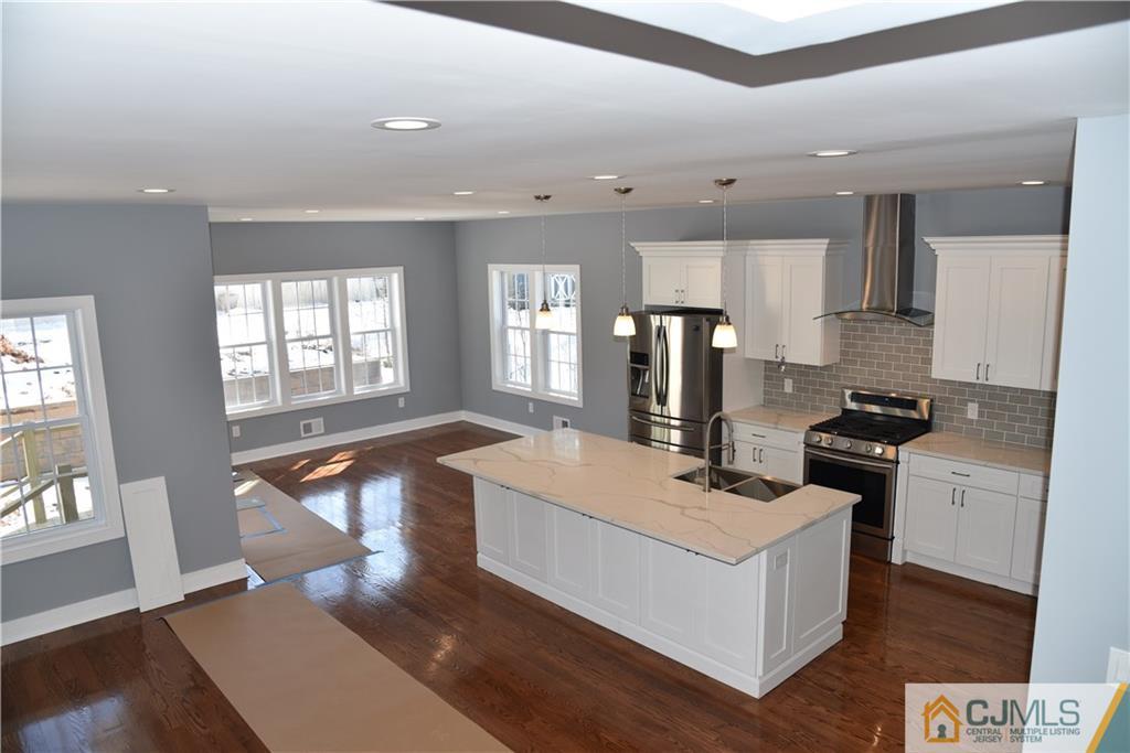 171 East Cliff Road Colonia, NJ 07067 - Photo 8 of 25 a large white kitchen with stainless steel appliances granite countertop a stove and a refrigerator