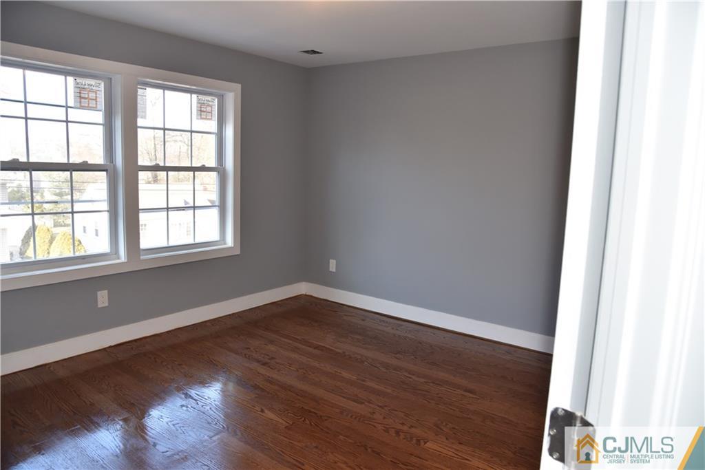 171 East Cliff Road Colonia, NJ 07067 - Photo 9 of 25 an empty room with wooden floor and windows