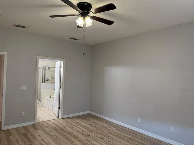 an empty room with closet and a chandelier fan
