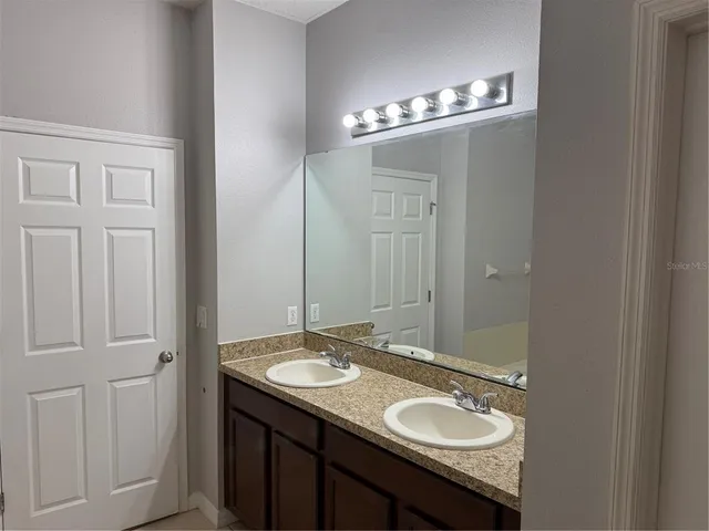 a bathroom with a granite countertop sink and a mirror