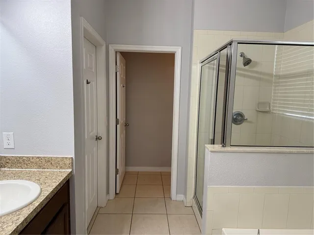 a bathroom with a granite countertop shower a mirror and a sink