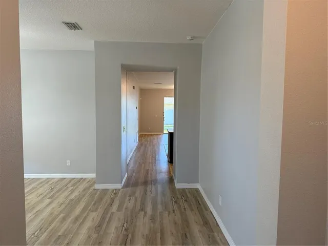 a view of a hallway with wooden floor