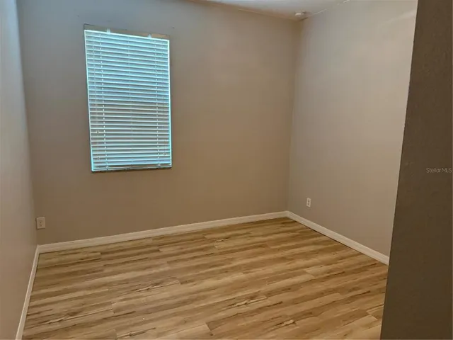 a view of a room with wooden floor and a window