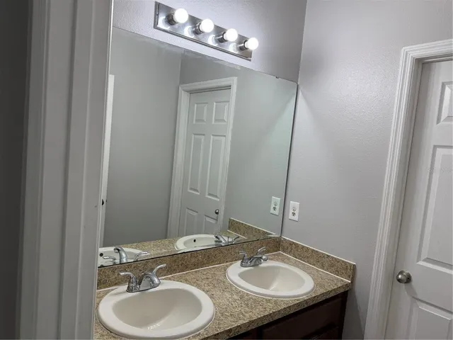 a bathroom with a sink double vanity and a mirror